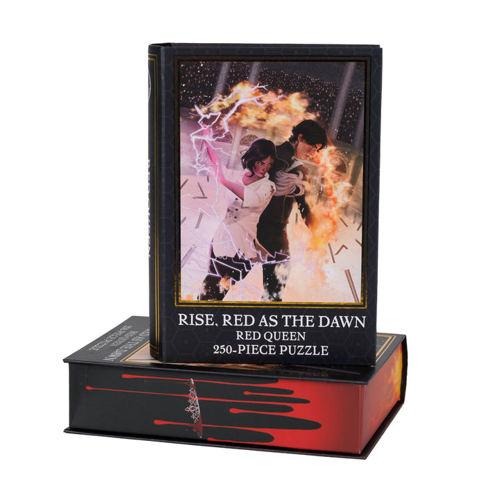 Book-shaped box for Rise, Red as the Dawn Red Queen 250-piece puzzle. Art on the front is of Mare and Cal wielding fire and lightning.