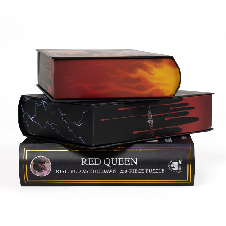 Stack of 3 puzzle boxes showing all sides. Edges with fire, lightning, or dripping blood. The spine of the box reads Red Queen Rise Red as the Dawn 250-piece puzzle.