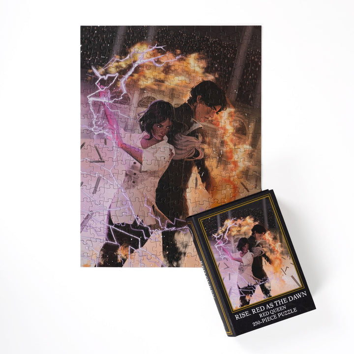 Completed puzzle of Mare and Cal wielding fire and lightning and black, book-shaped box with matching art for Rise, Red as the Dawn Red Queen 250-piece puzzle