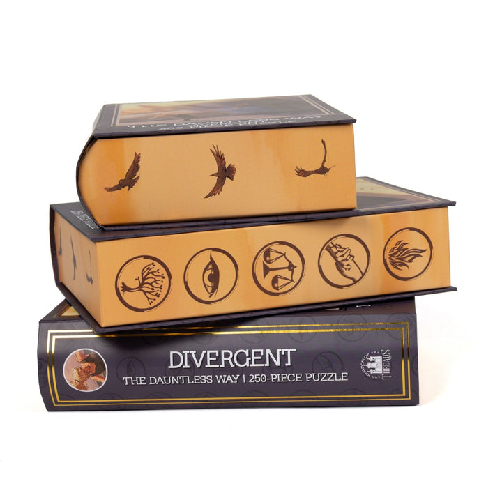 Stack of 3 puzzle boxes showing all sides. Yellow gold edges with the Divergent faction symbols in purple. The spine of the box reads Divergent The Dauntless Way 250-piece puzzle.