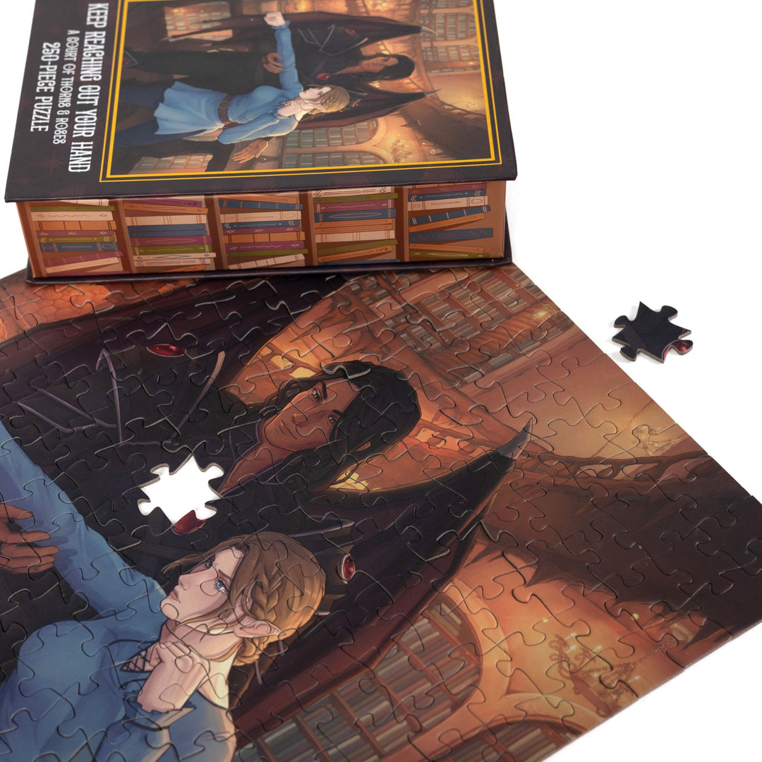 Close up of completed puzzle of Nesta and Cassian from A Court of Thorns and Roses with one piece missing.