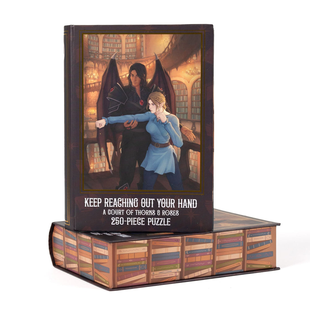 Book-shaped brown box for Keep Reaching Out Your Hand A Court of Thorns and Roses 250-piece puzzle. Art on the front is of Nesta and Cassian.