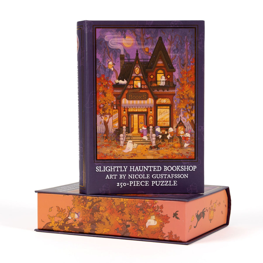 Book-shaped black box for Slightly Haunted Bookshop 250-piece puzzle. Art on the front is of cute ghosts visiting a bookstore. 
