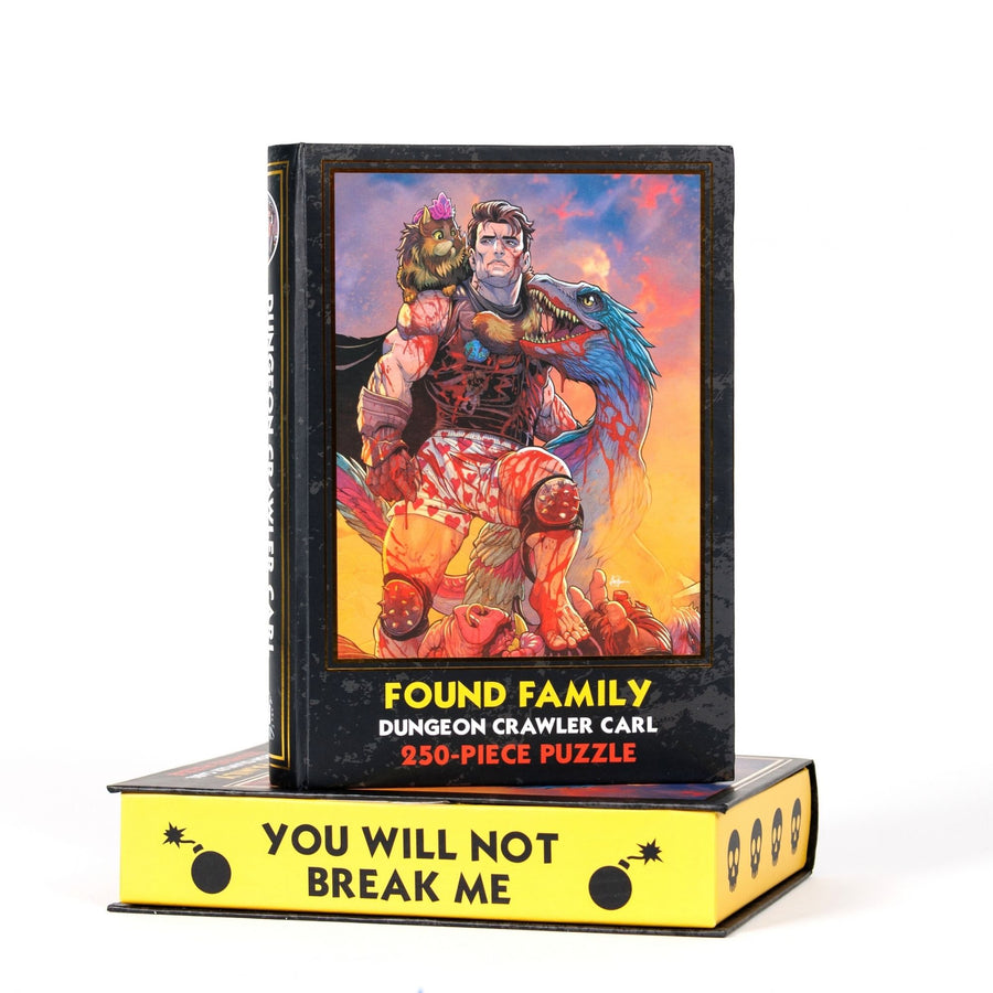Book-shaped black box for ‘Found Family Dungeon Crawler Carl 250-piece puzzle. Art on the front is of Carl, Princess Donut and Mongo.
