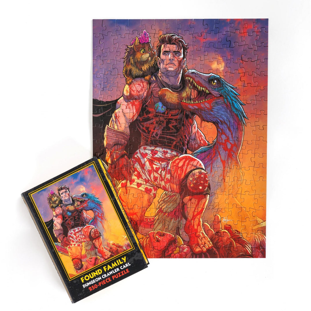 Full completed puzzle of Carl, Princess Donut, and Mongo and black, book-shaped box with matching art for ‘Found Family Dungeon Crawler Carl 250-piece puzzle.’