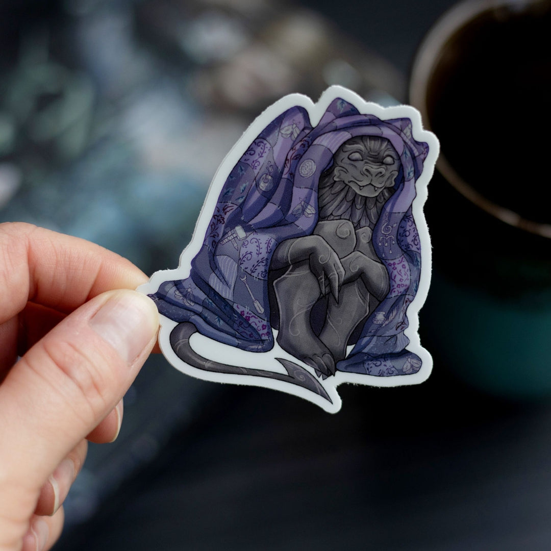 Sticker of a gargoyle sitting underneath a purple blanket held over The Knight and the Moth by Rachel Gillig. The character is Bartholomew.