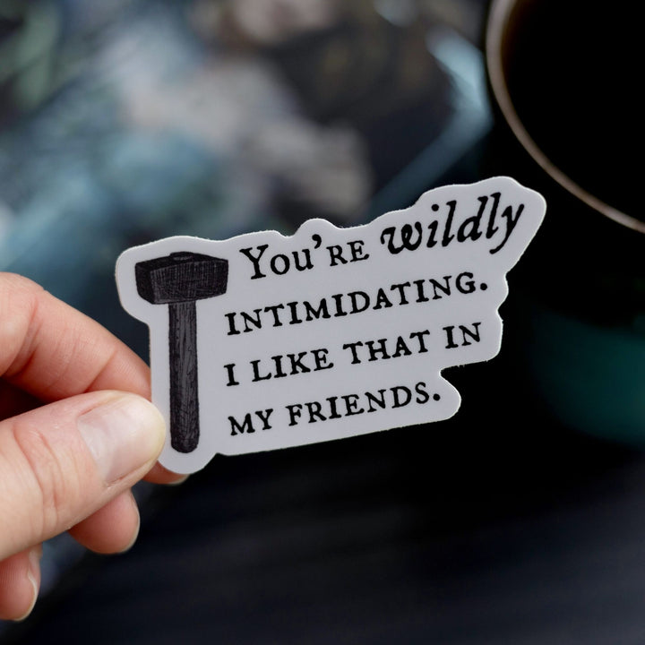 Quote sticker ‘You’re wildly intimidating. I like that in my friends’ held over The Knight and the Moth. Light purple sticker with dark text and a hammer.