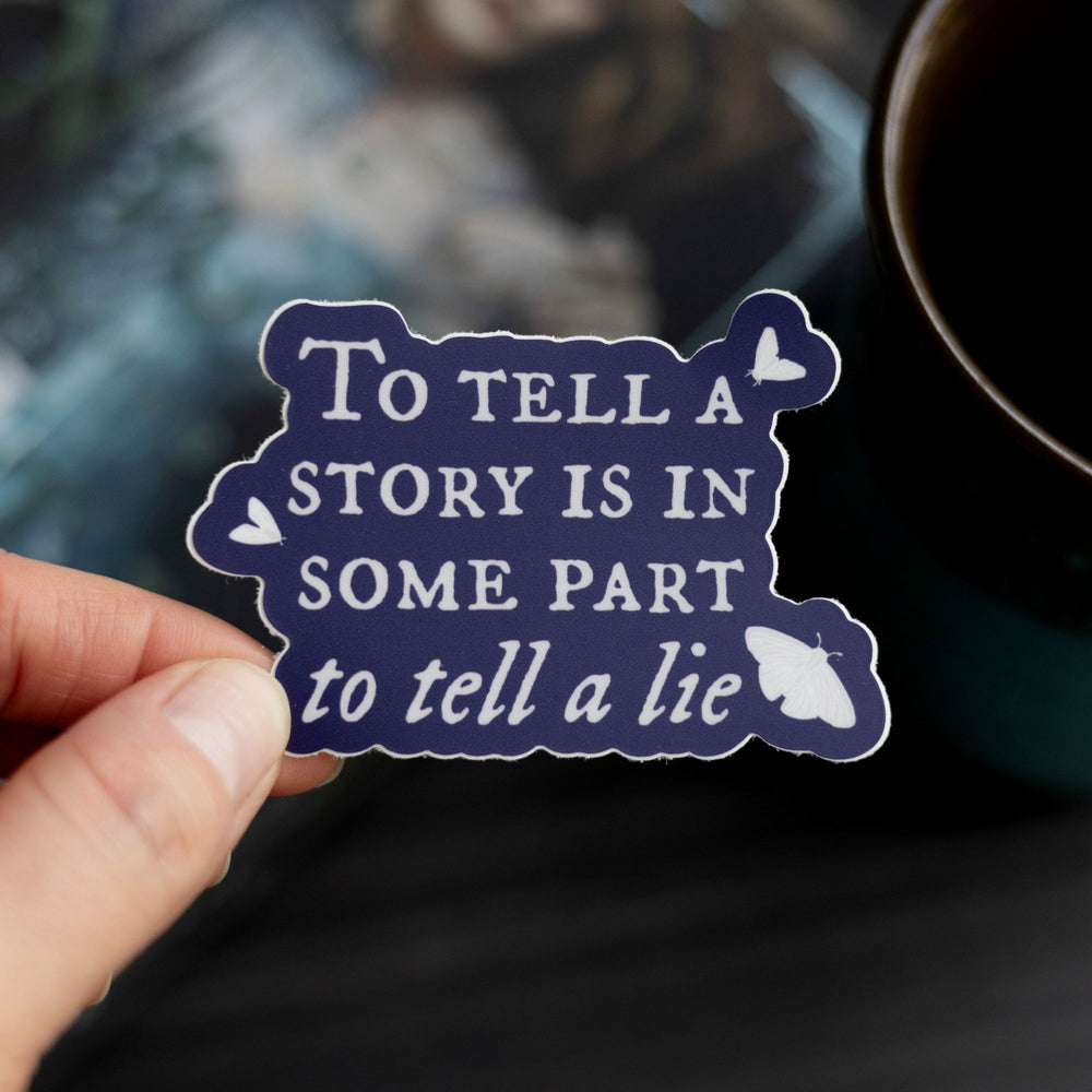 Quote sticker ‘To tell a story is to in some part tell a lie’ held over The Knight and the Moth. Dark purple sticker with white text.