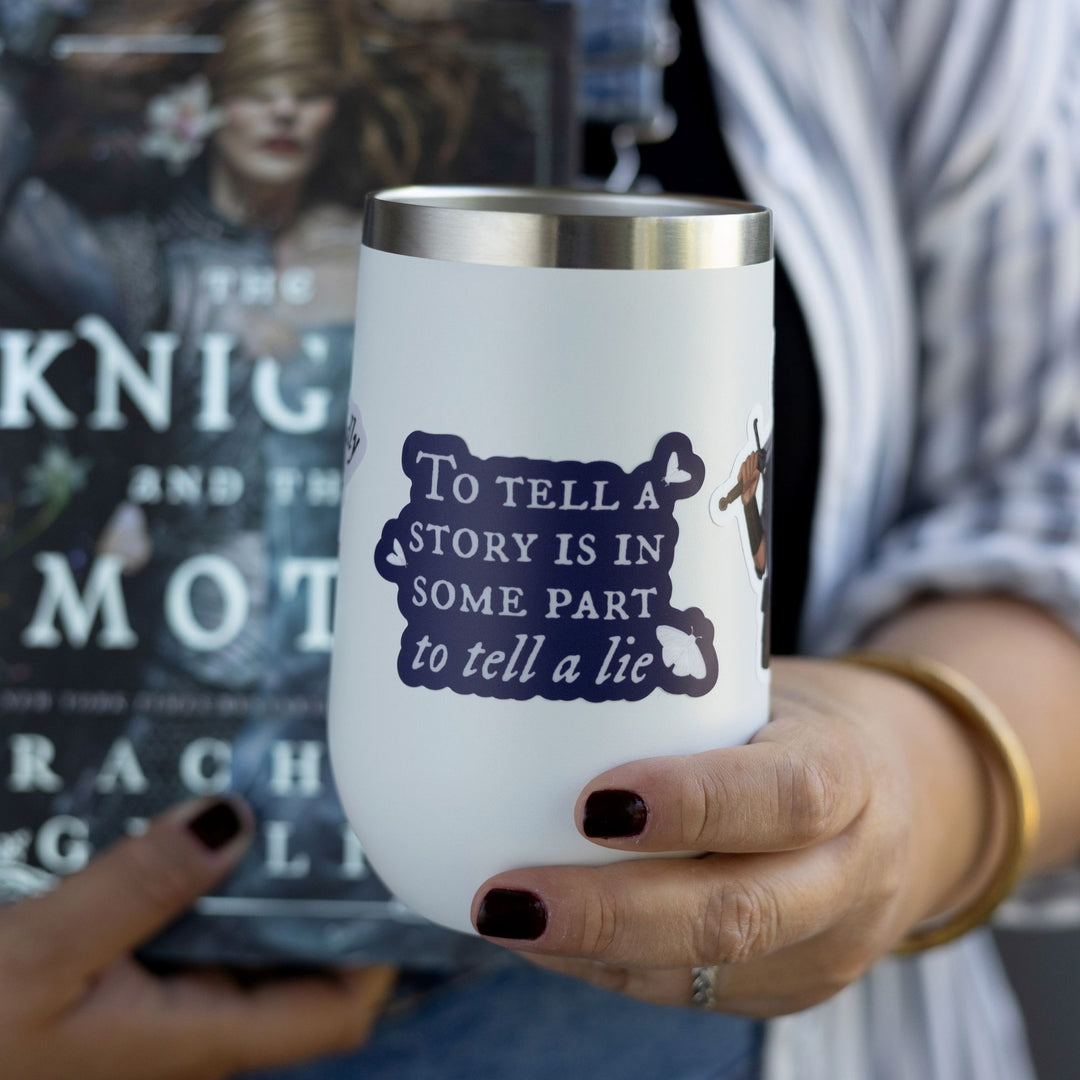 Quote sticker from Knight and the Moth ‘To tell a story is to in some part tell a lie’ on a white tumbler. Dark purple sticker with white text.