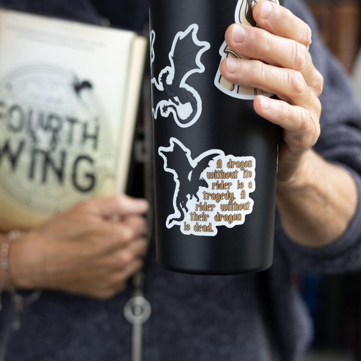 Quote sticker: ‘A dragon without their rider is a tragedy. A rider without their dragon is dead.’ Gold text & a black dragon on a black tumbler
