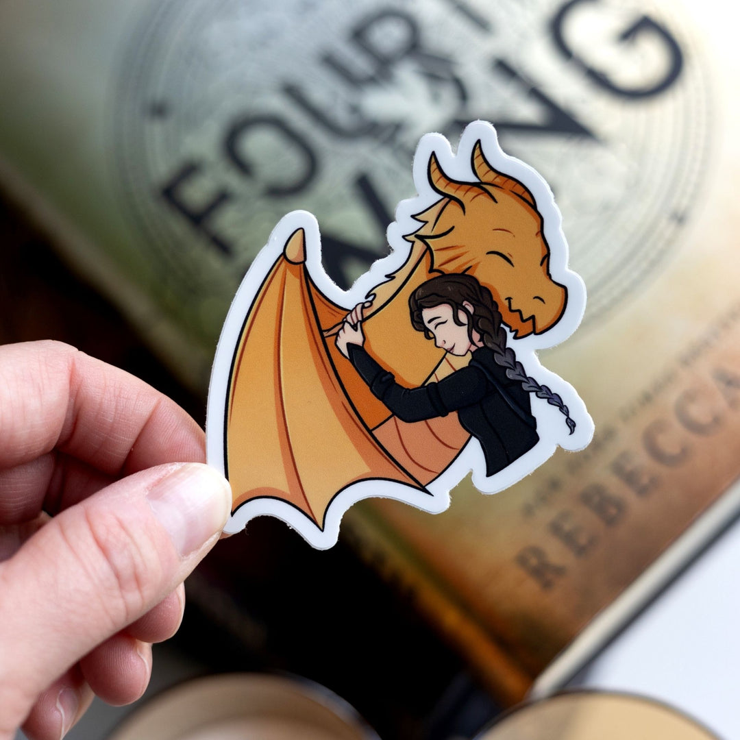 Sticker of Violet Sorrengail hugging her golden dragon, Andarna. Characters from Fourth Wing. Held over Fourth Wing.