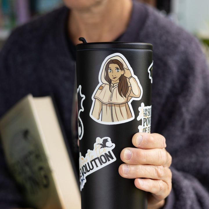 Sticker of Jesinia the scribe from Fourth Wing. She has long, brown hair & cream colored robes with the hood up, on a black tumbler. 
