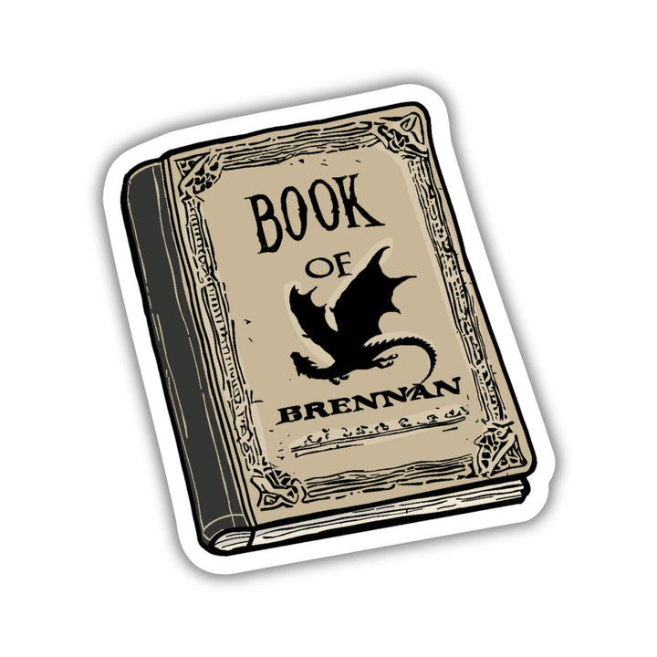Sticker of a parchment colored book with a black dragon that says Book of Brennan. 
