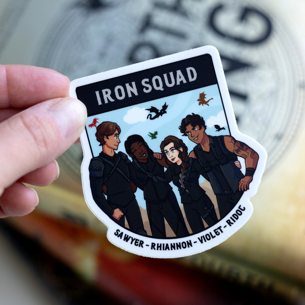 Sticker of the Iron Squad in riding leathers, arm in arm and smiling, with dragons flying behind them. Their names ‘Sawyer, Rhiannon, Violet, and Ridoc’ are on the bottom. Held over Fourth Wing.