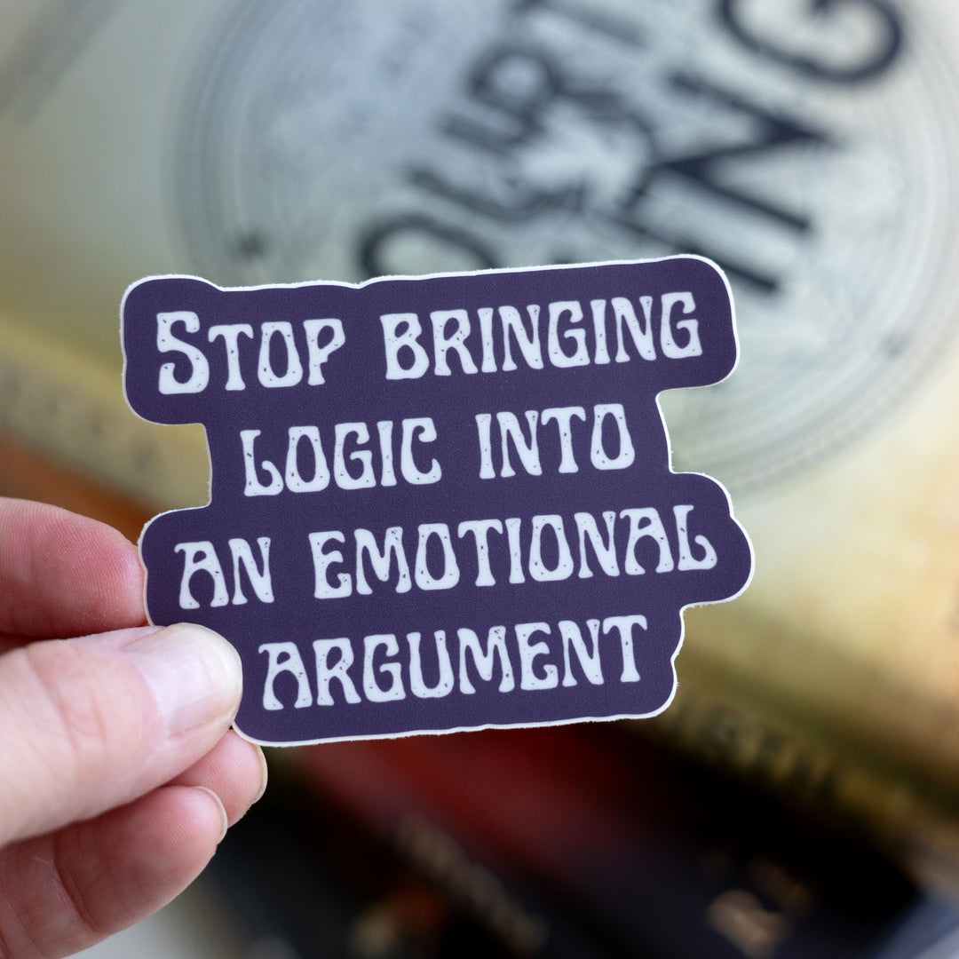 Fourth Wing quote sticker: ‘Stop bringing logic into an emotional argument.’ In white letters on a purple background. Held over Fourth Wing.