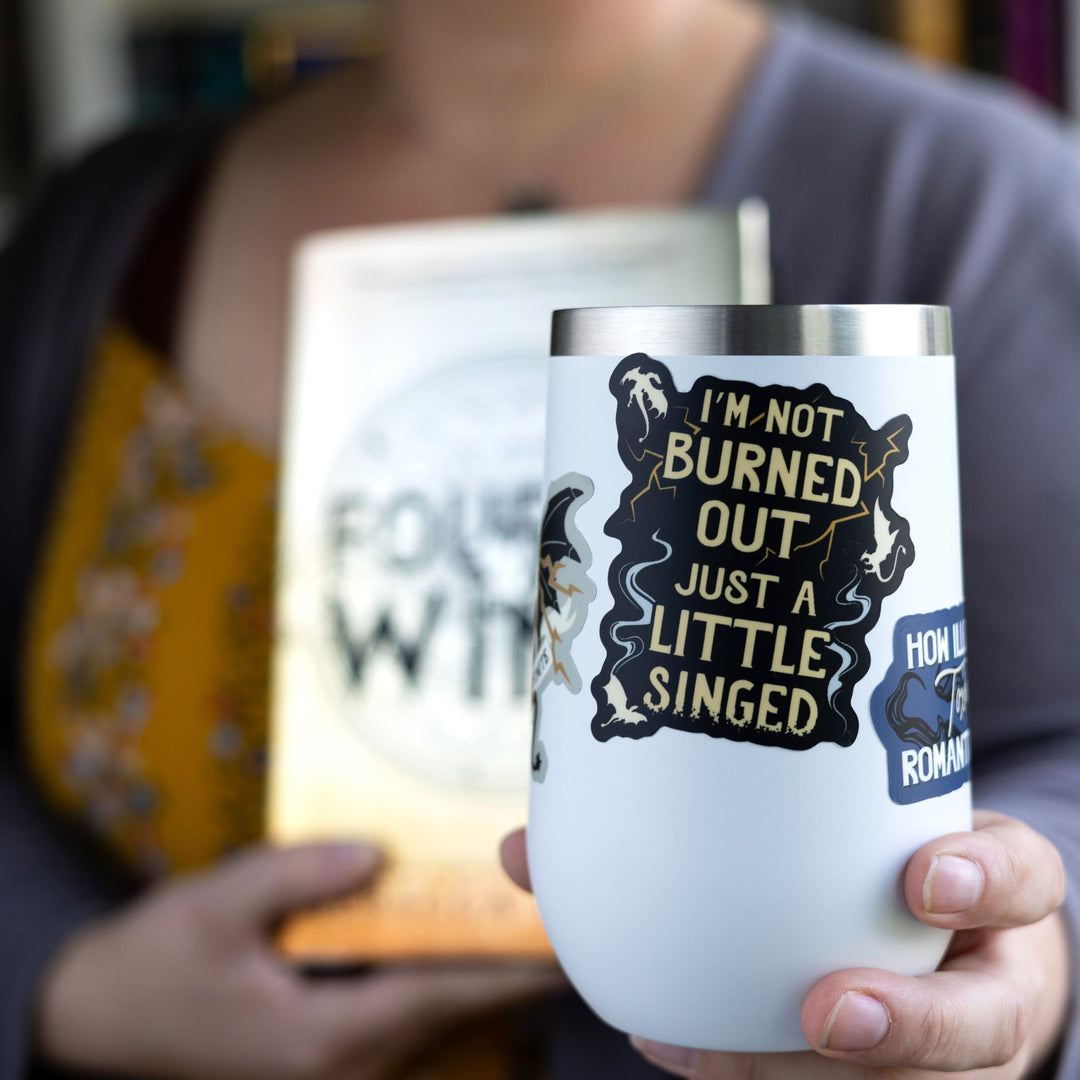 Sticker that reads ‘I’m not burned out just a little singed’ with lightning and smoke.  On a white tumbler.