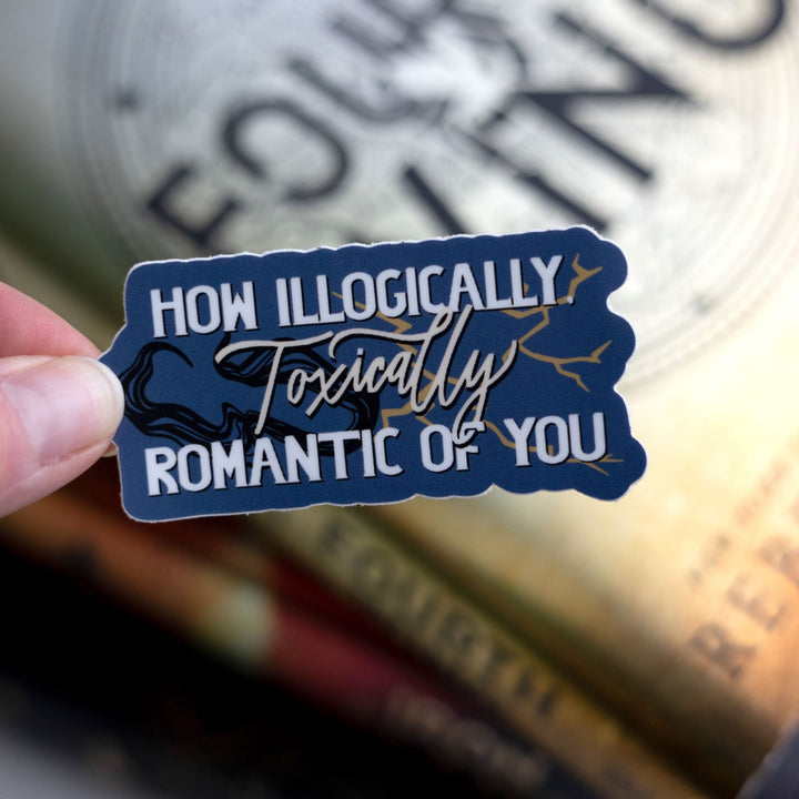 Quote sticker from Onyx Storm reads ‘How illogically, toxically romantic of you’ with shadows and lightning. Held above Fourth Wing.