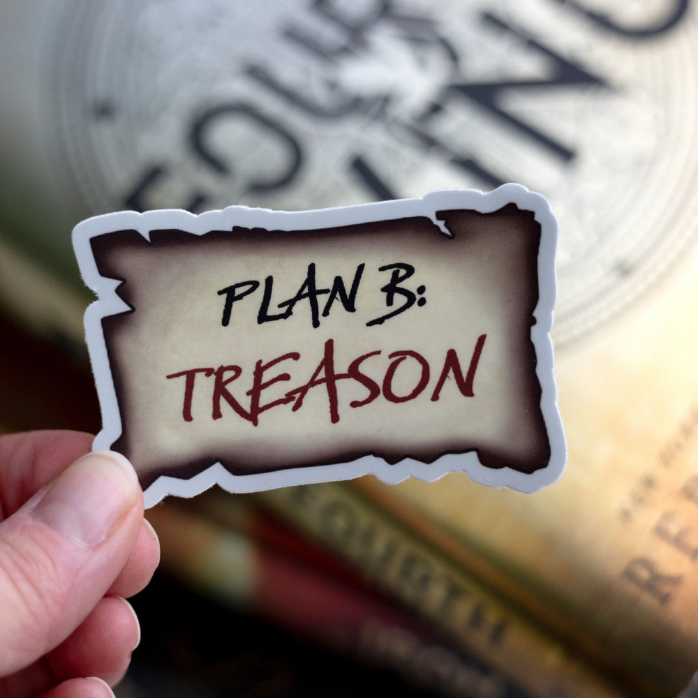 Sticker of a piece of parchment that reads ‘Plan B: Treason’, from Iron Flame. Held above Fourth Wing.