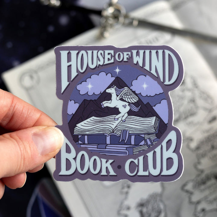 Sticker of a white and purple pegasus that says ‘Do it for the miniature pegasus around the circle. Held above a map.
