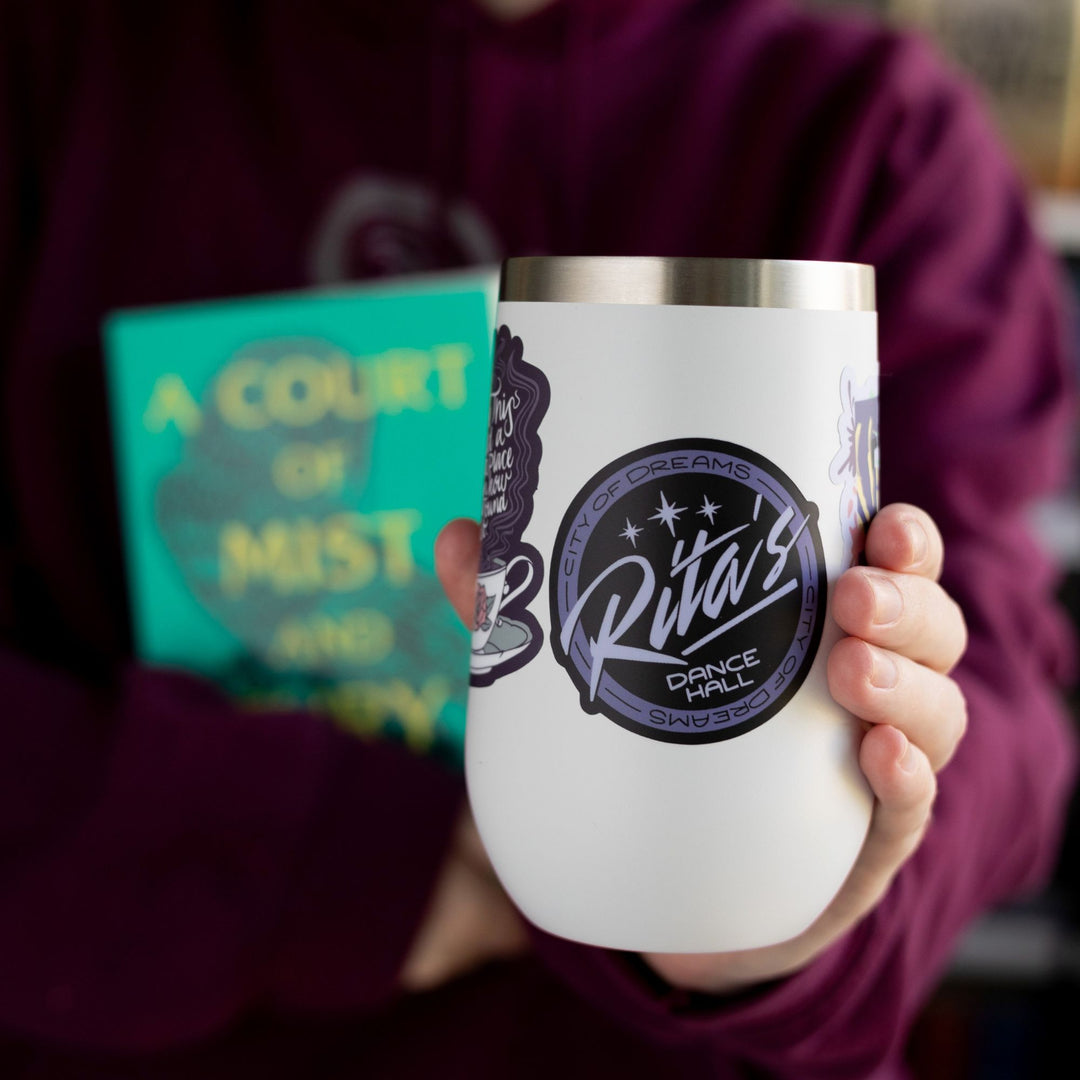  Logo sticker of Rita’s dance hall from ACOTAR, around the edges reads ‘City of Dreams’. On a white tumbler.
