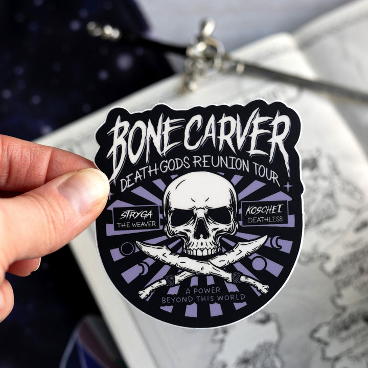  Sticker in a concert poster style with a skull that reads ‘Bonecarver Death Gods Reunion Tour, Stryga the Weaver, Koschei Deathless, a power beyond this world.’ Held above a map.

