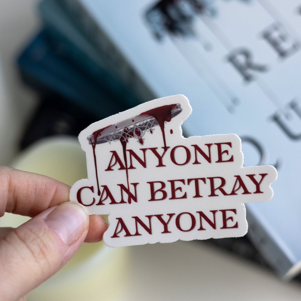 Red Queen quote sticker: ‘Anyone can betray anyone’ in red beneath an upside down crown dripping blood, held over Red Queen.