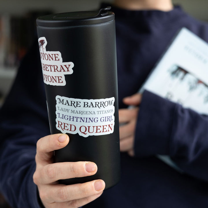 Sticker for Red Queen that lists all the names for Mare Barrow in a stack. Text is ‘Mare Barrow, Lady Mareena Titanos, Lightning Girl, Red Queen.’ On a tall black tumbler.